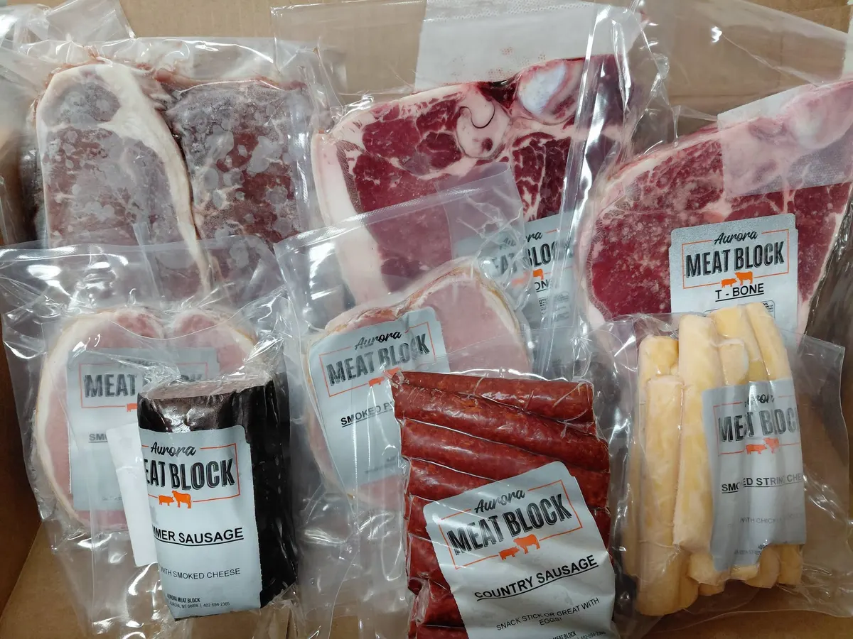 Vacuum-packed steaks, sausage, snack sticks and cheese, each with a printed insert showing through the clear film