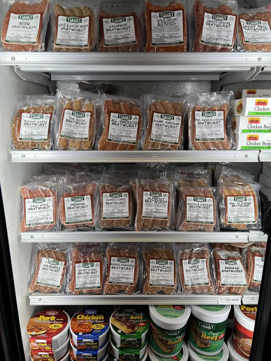 Cooler shelves stocked with rows of packaged sausage, every pack carrying the same printed label