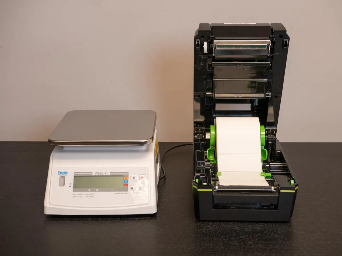 Economarker printer with its cover open, showing a roll of blank labels loaded